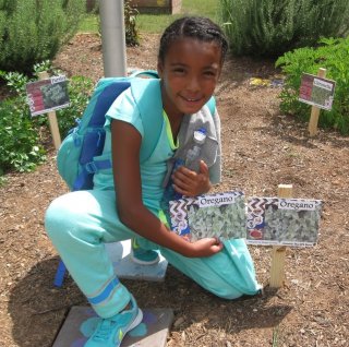 student in the garden with seed packets