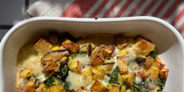 breakfast frittata in a while baking dish with red striped towel in background