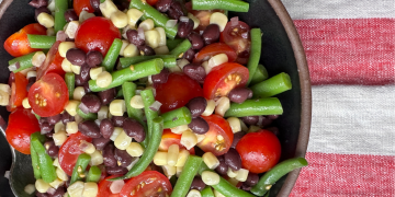 corn, green bean, black bean, tomato salad with a red and white dish towel