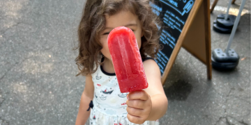 kid with popsicle at market