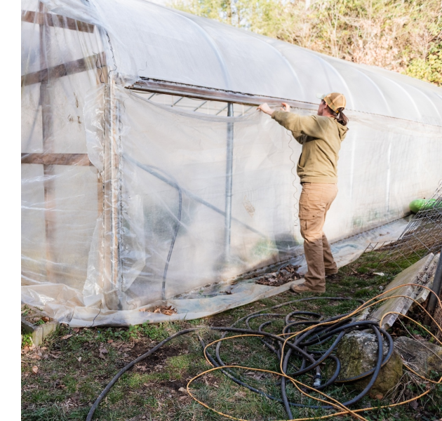A farmer rebuilds a high tunnel after damage from Hurricane Helene